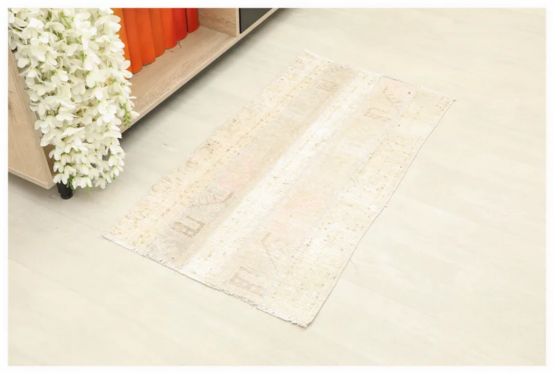 Full overhead view of the beige and rose patchwork mini rug on a white background