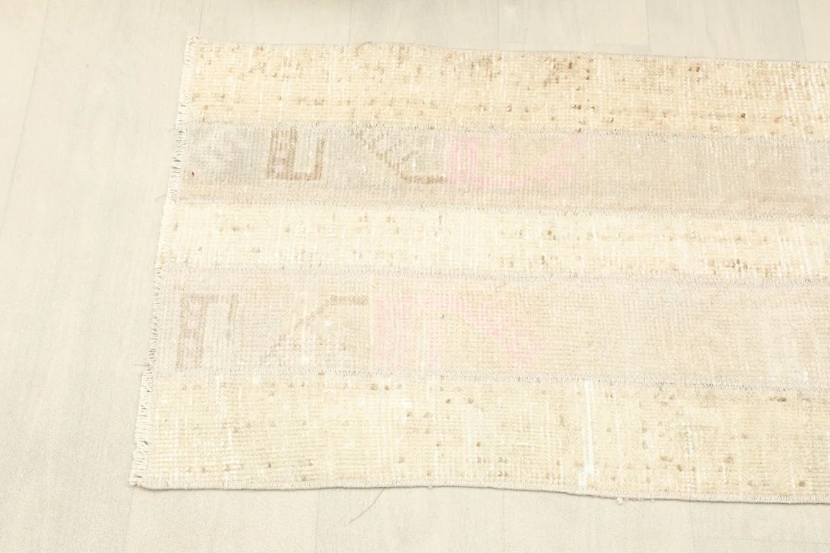 Corner view of the rug laid flat, showcasing the full length and subtle distressing