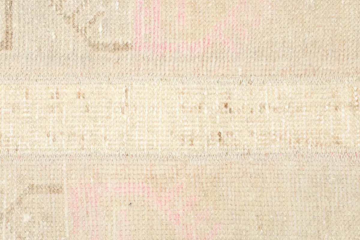 Detailed view of the hand-knotted wool pile, showing texture and muted colors