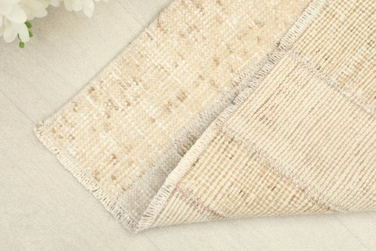 Close-up of the rug's corner, showing the wool pile and cotton foundation texture