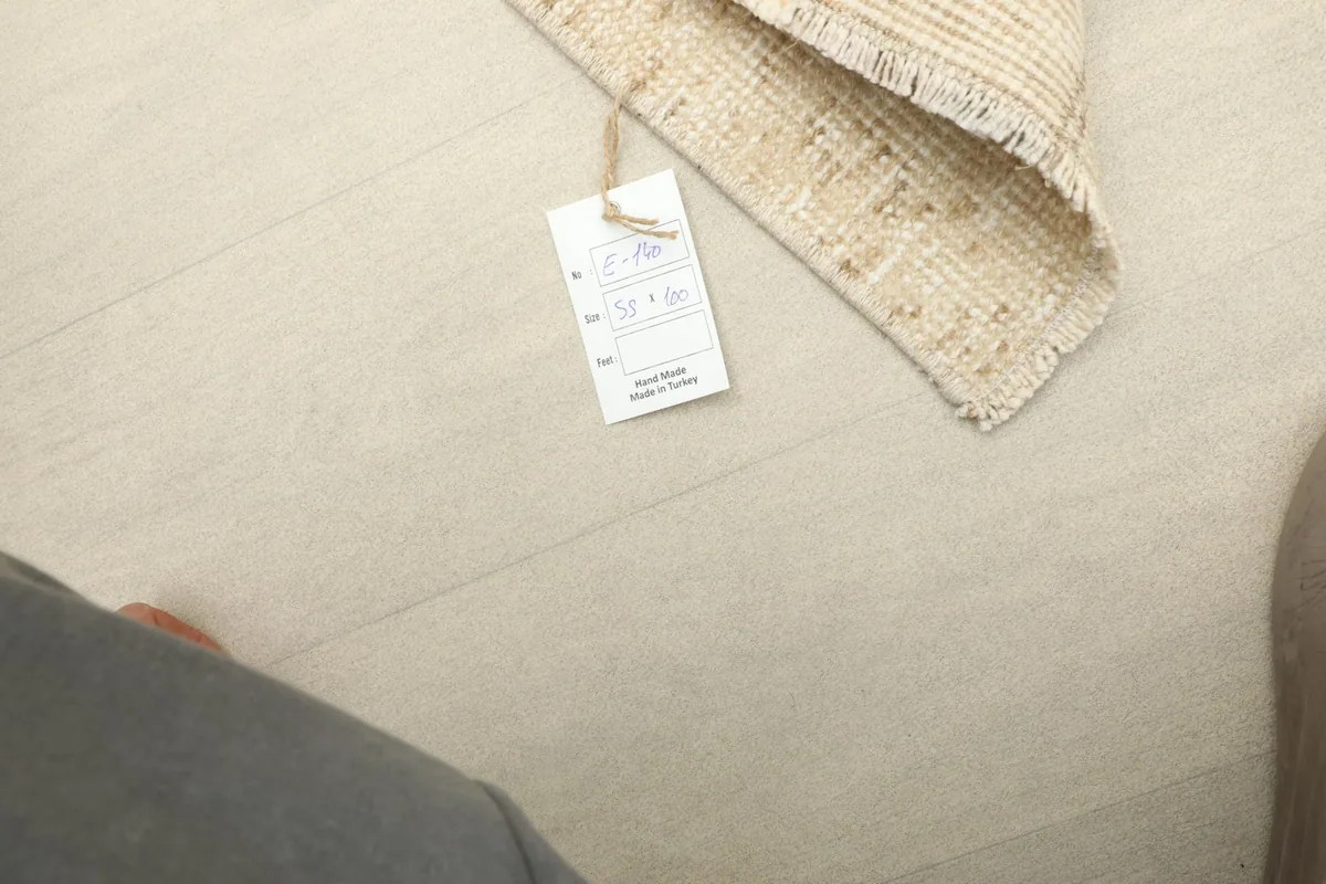 View of the product tag attached to the rug, indicating its details and origin