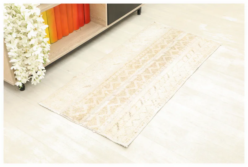 Full top view of the beige and tan geometric vintage Anatolian rug on a white background.