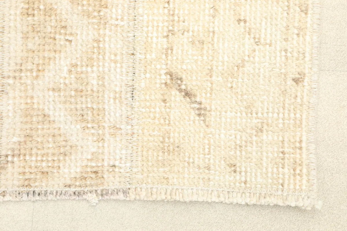 Close-up detail of the rug's corner, showing the low pile and fringe.