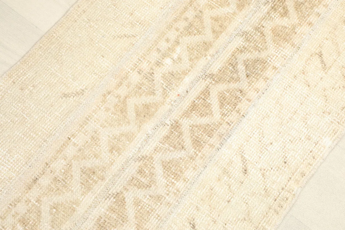 Detailed view of the central geometric patterns and color variations in the rug's pile.