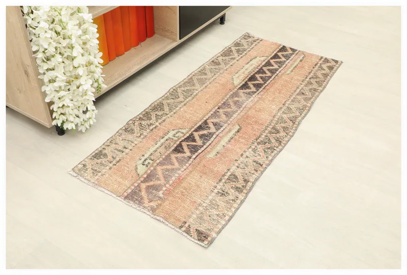 Full top view of the rose and brown geometric vintage Anatolian rug on a white background.