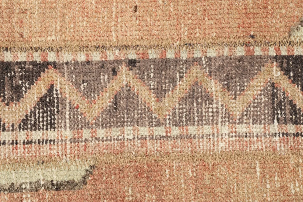 Detailed shot of a brown and rose chevron pattern within the rug's design.