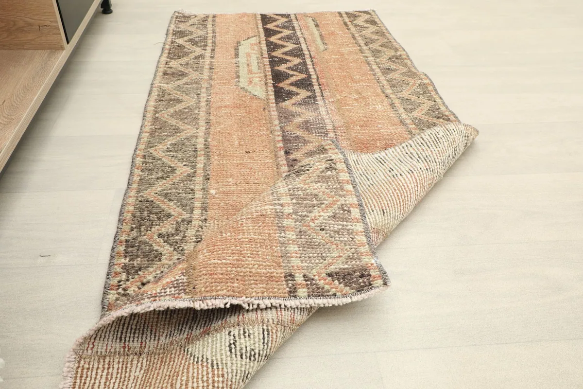 The rug partially folded, illustrating its flexibility and the texture of the wool pile.