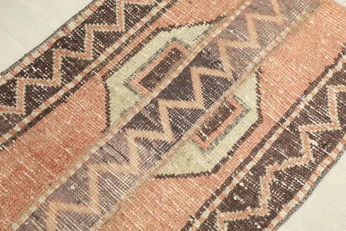 Angled view of the runner, highlighting the geometric motifs and the subtle color variations.