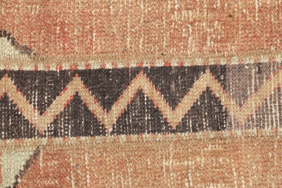 Detailed view of the zigzag pattern and color blending in the hand-knotted wool pile.