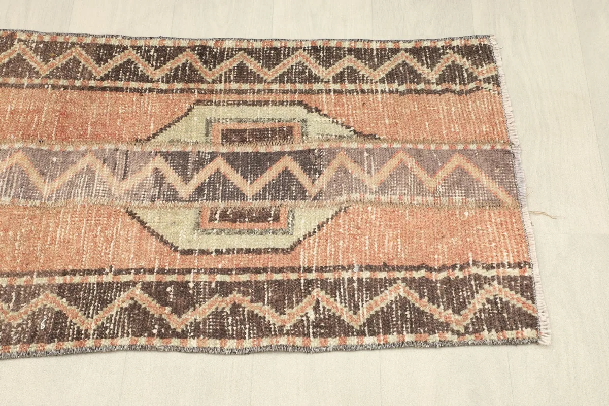 View of the opposite end of the runner, showcasing the geometric border and central motifs.