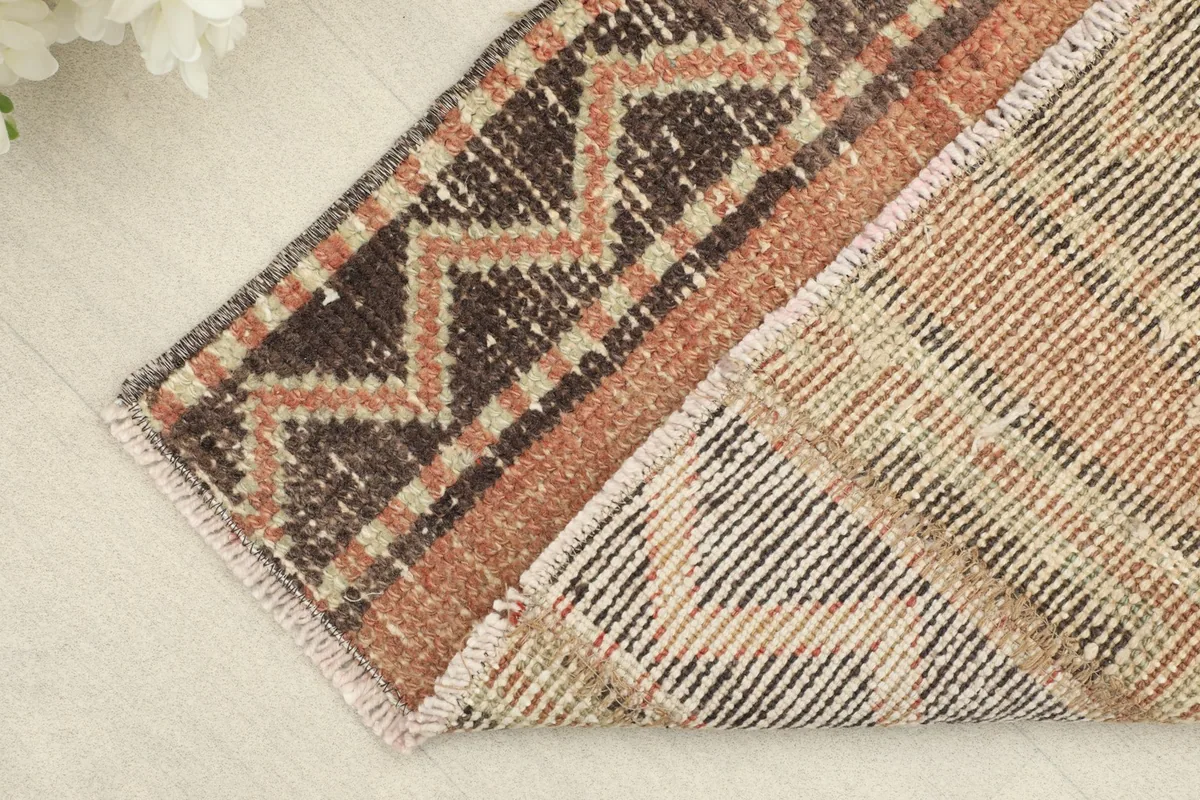 Close-up of the folded corner revealing the back of the hand-knotted rug and its cotton foundation.