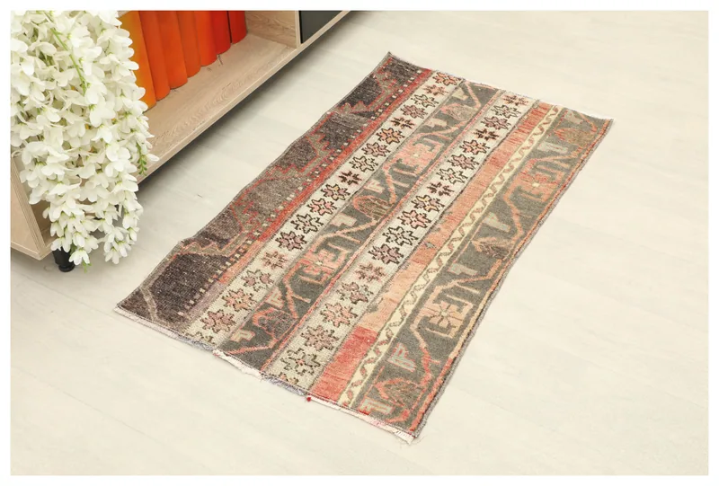 Full top view of the 1'11" x 3'4" vintage Anatolian area rug with charcoal and rust geometric stripes.