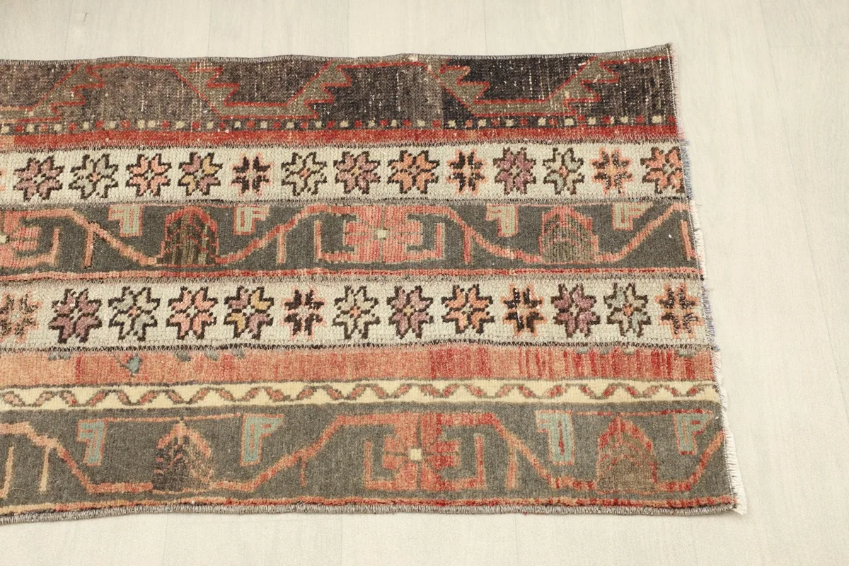 Angled view of the other end of the rug, displaying the full width of the patterned stripes.