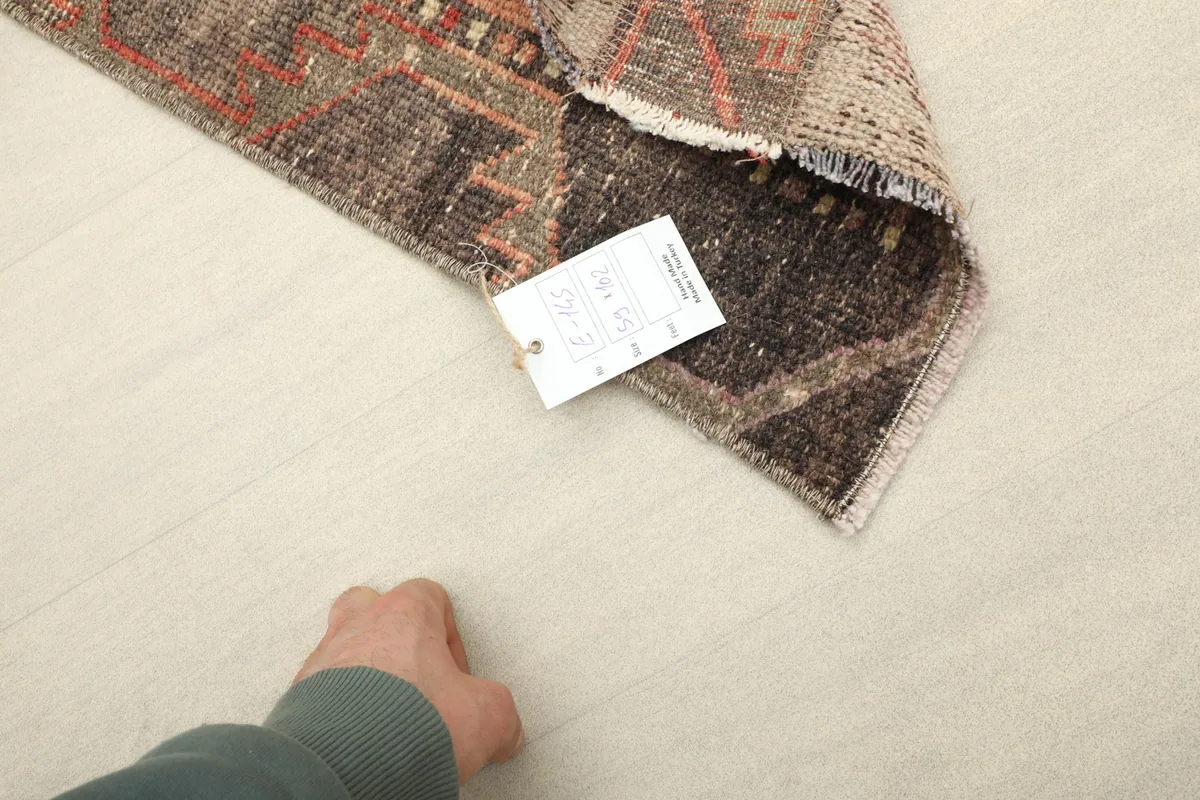Back of the hand-knotted rug with a tag, showing the intricate knotting and craftsmanship.