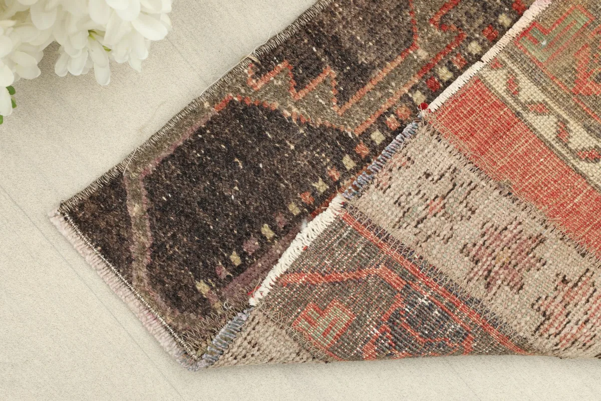 Corner of the rug folded back to show the wool pile and cotton foundation.