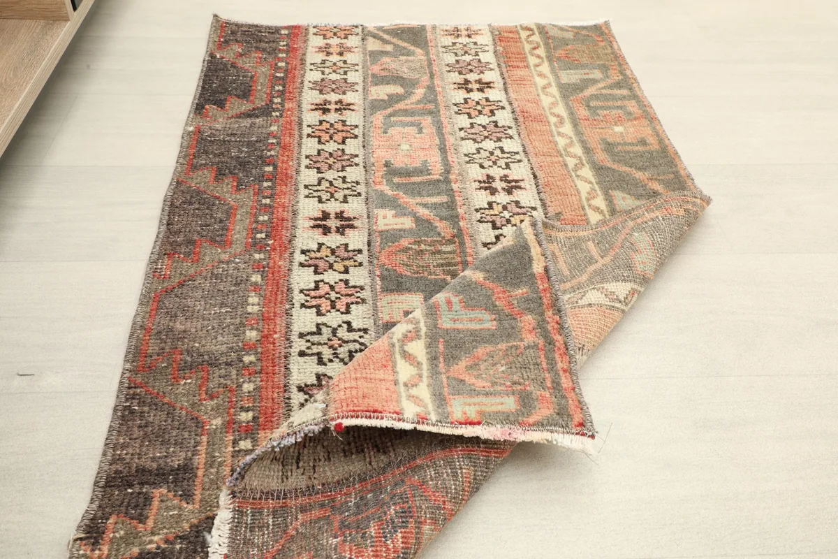 Rug partially folded, illustrating its flexibility and the texture of the vintage wool.