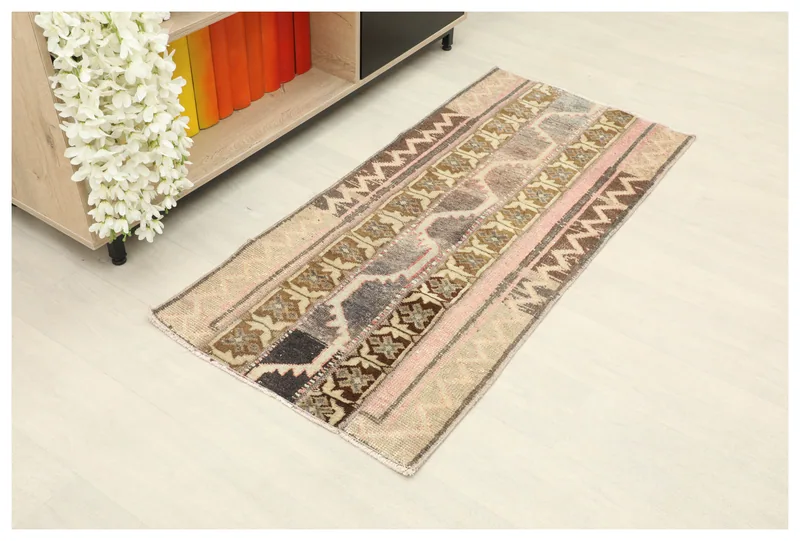 Full top view of the beige and pink patchwork area rug on a light floor