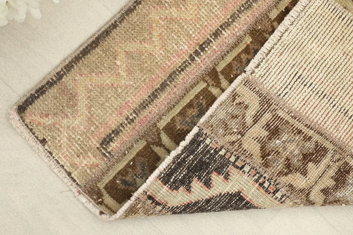 Corner of the rug folded to reveal the back of the hand-knotted cotton foundation