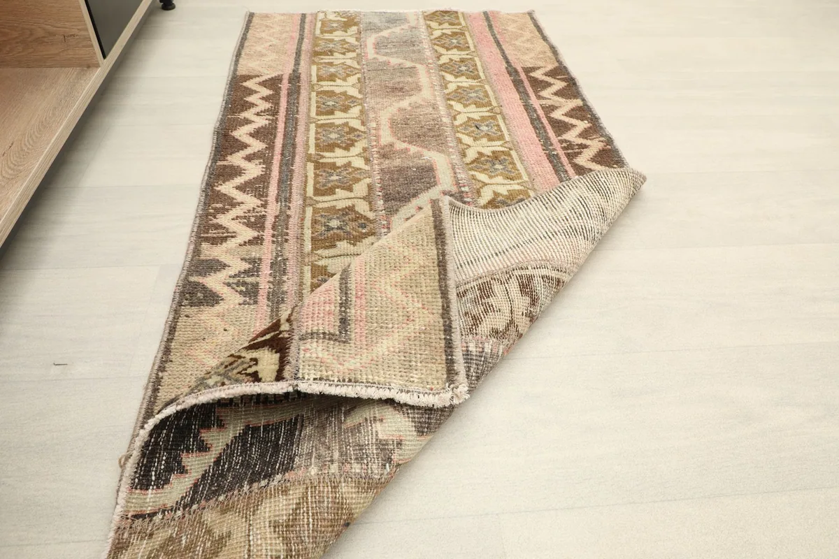 Rug partially folded, showcasing the thickness and texture of the vintage wool pile