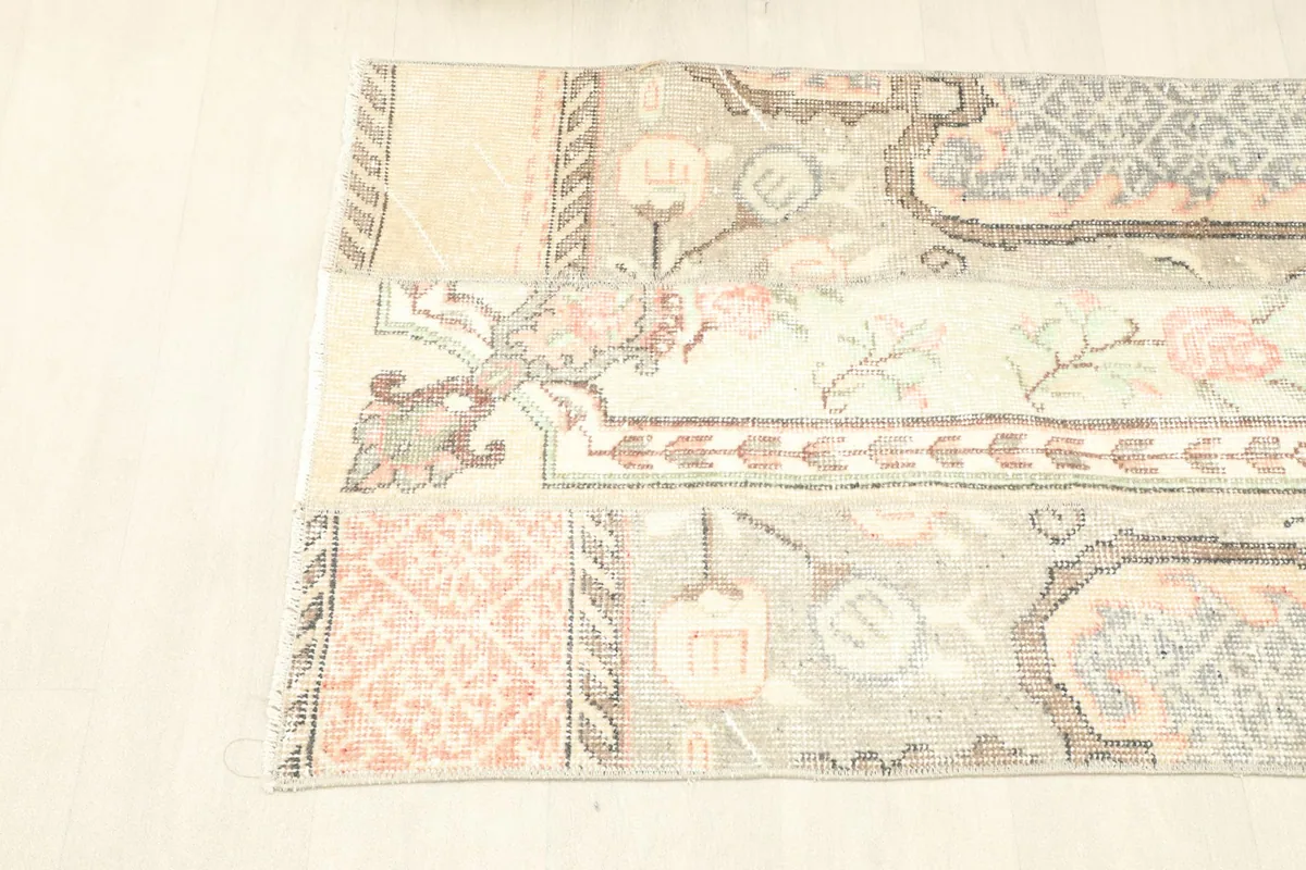 Overhead shot focusing on the left side of the rug, showing the blend of floral and geometric elements.