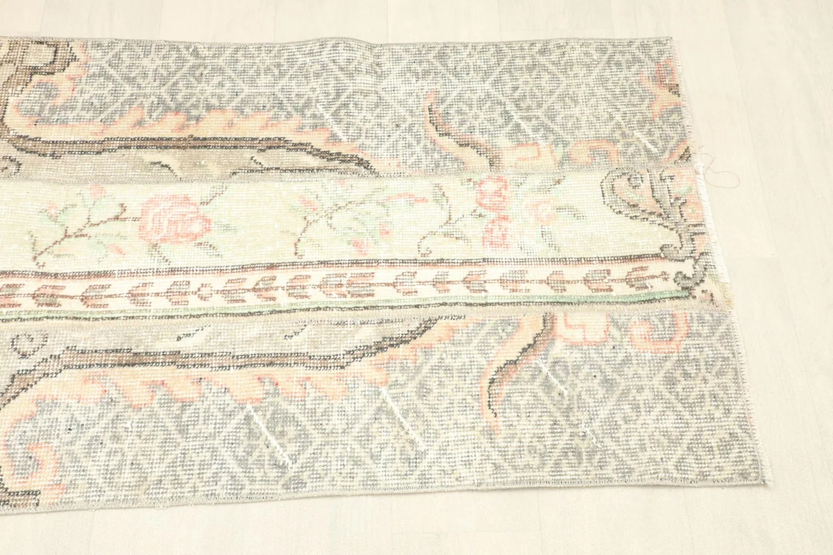 Overhead shot focusing on the right side of the rug, displaying the gray geometric and rose patterned sections.