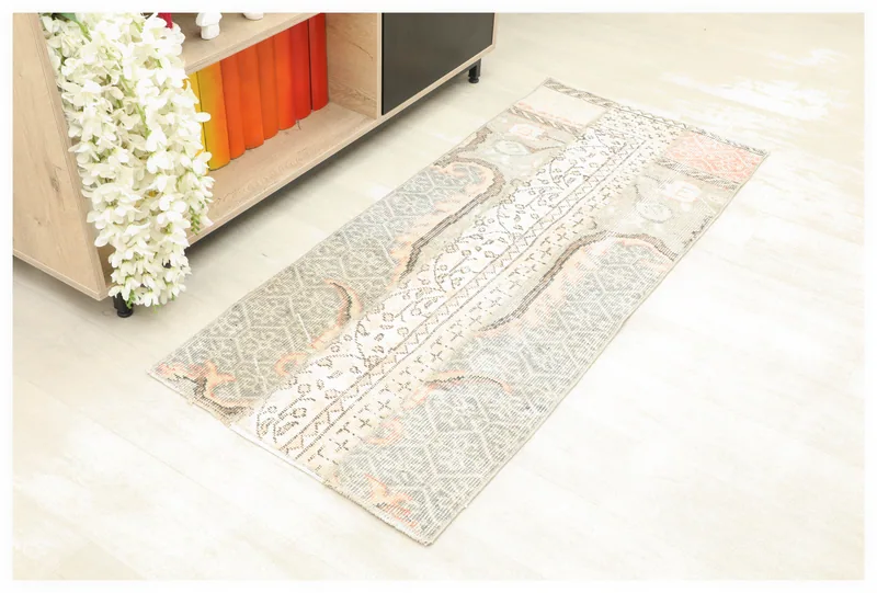 Full top view of the gray, ivory, and rust vintage Anatolian rug on a white background.