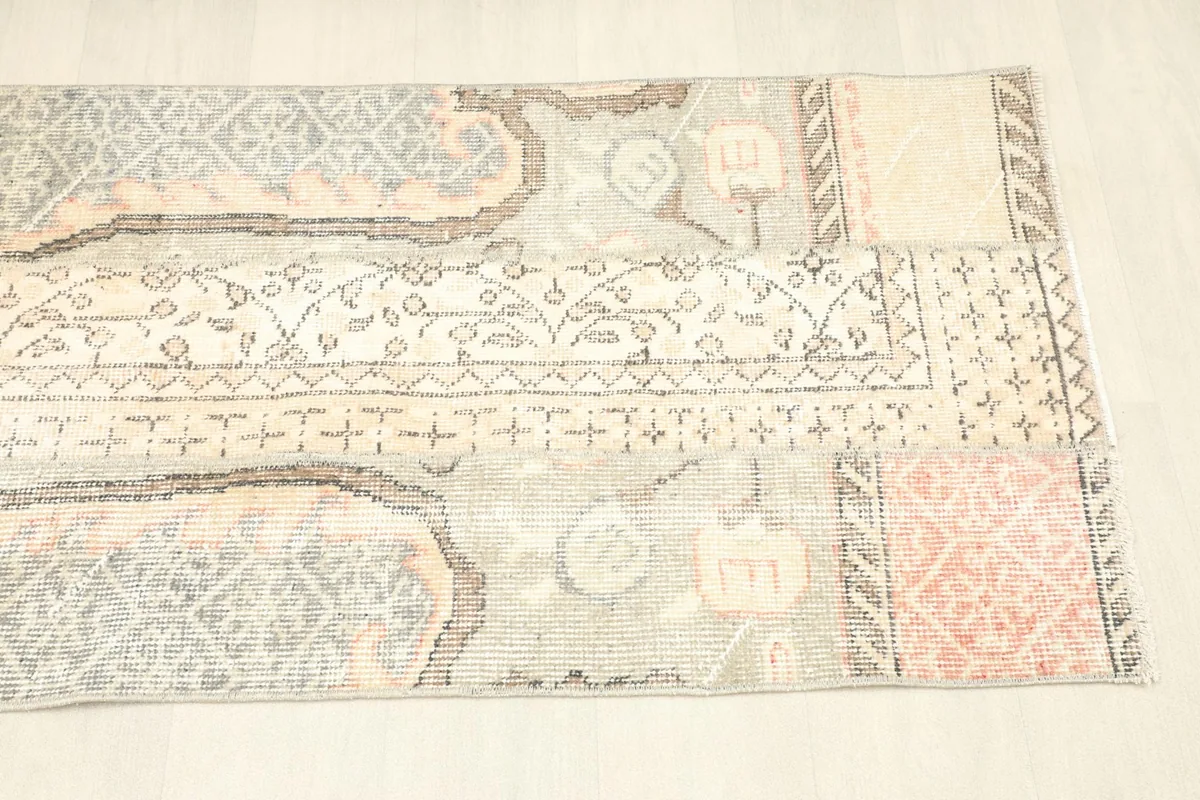 Angled shot of the rug's end, revealing the border design and color variations.