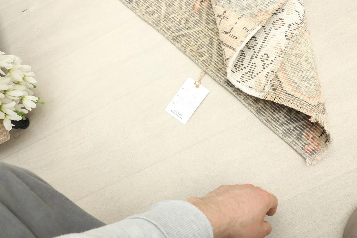 View of the rug's back and a small tag, indicating its hand-knotted construction.