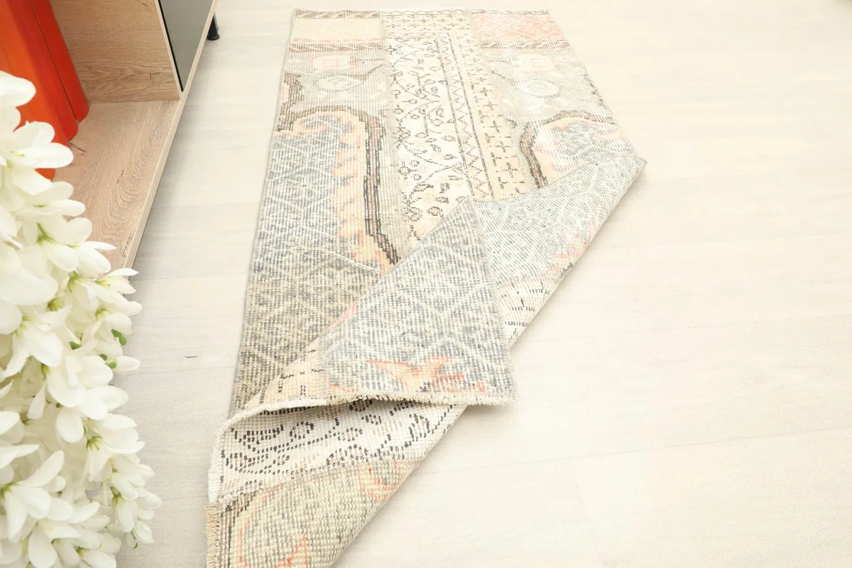 Partially rolled rug, displaying its flexibility and the different sections of its design.