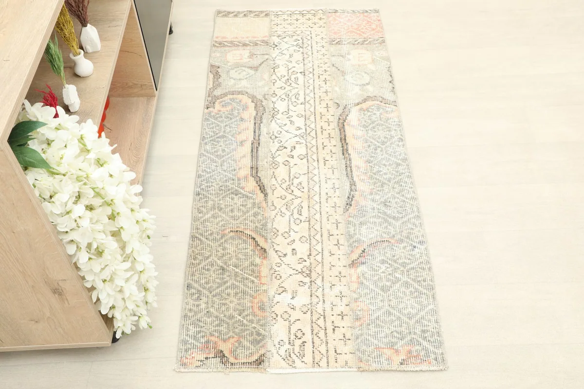 Overhead view of the hand-knotted vintage rug, showing its full length and muted colors.