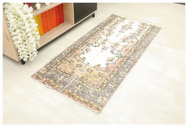 Full top view of the 2'5" x 5'3" ivory and pink floral vintage Anatolian runner on a white background.