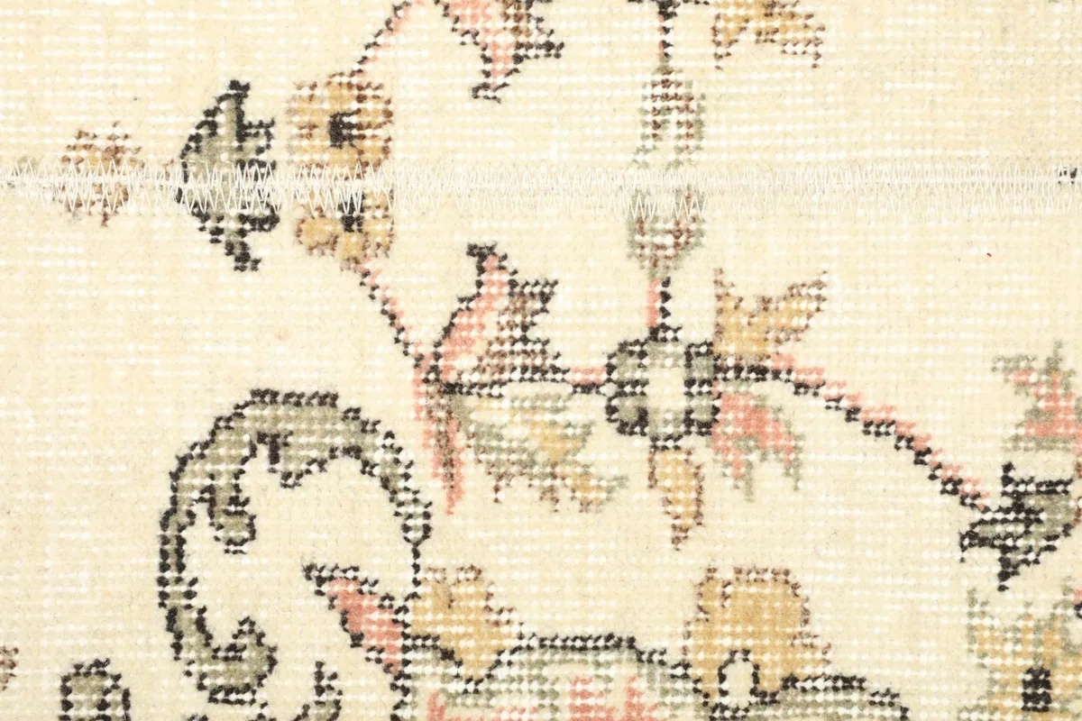 Detailed close-up of the low wool pile and the intricate floral design, showing texture and color variations.