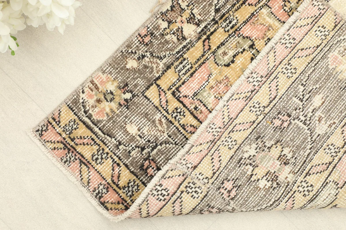 View of the rug folded, showing the backside of the hand-knotted wool pile on a cotton foundation.