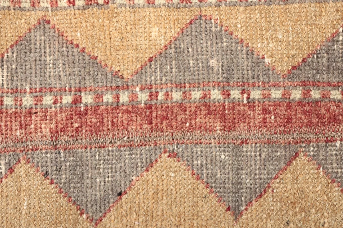 Detailed view of the central geometric motifs and color blend in the rug's pile.