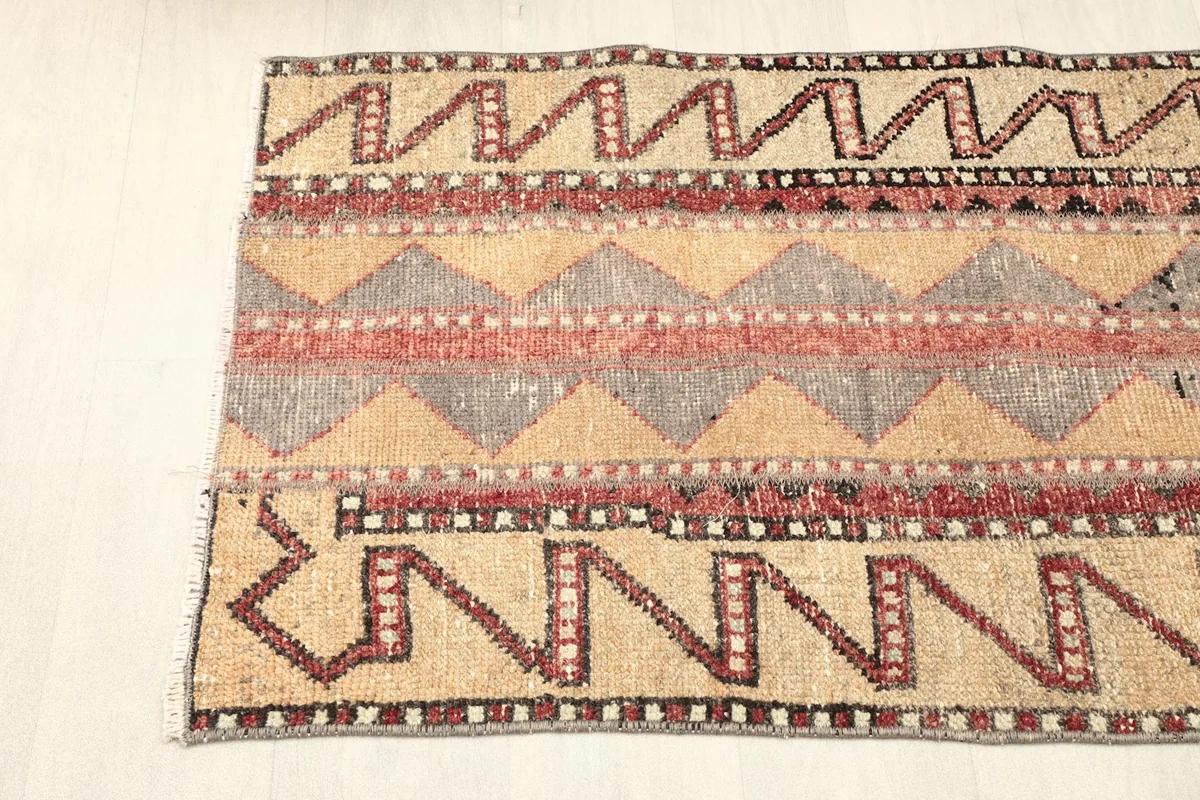 View of the rug's side border, showing the unique zigzag and linear patterns.