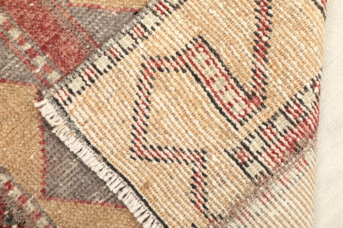 Close-up showing the low pile and hand-knotted wool construction of the vintage rug.