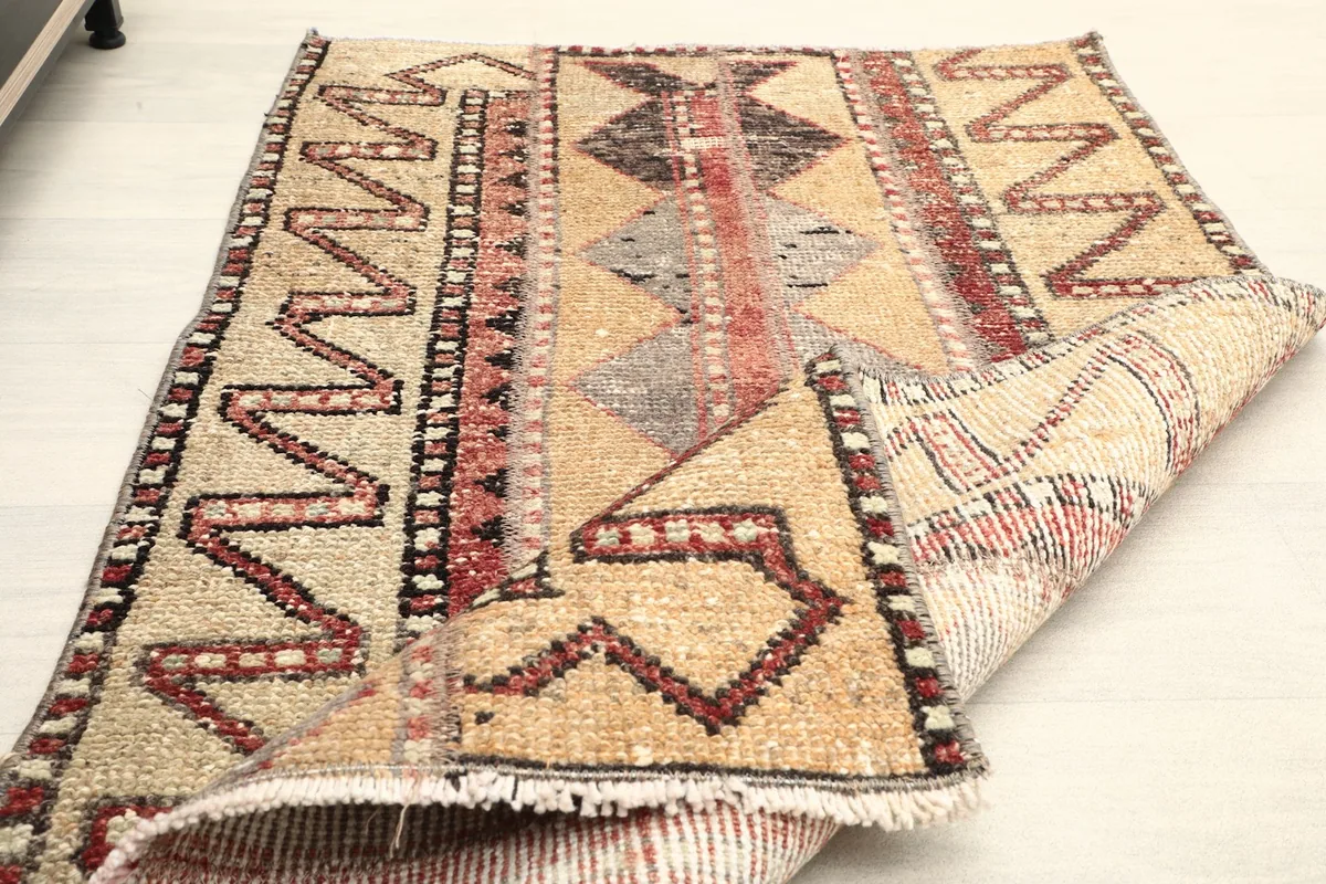 The rug partially folded, displaying its flexibility and the reverse side of the weave.