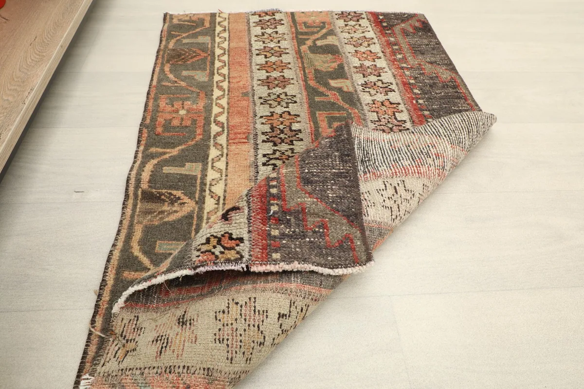 Rug partially folded, showcasing the thickness of the wool pile and the hand-knotted construction.