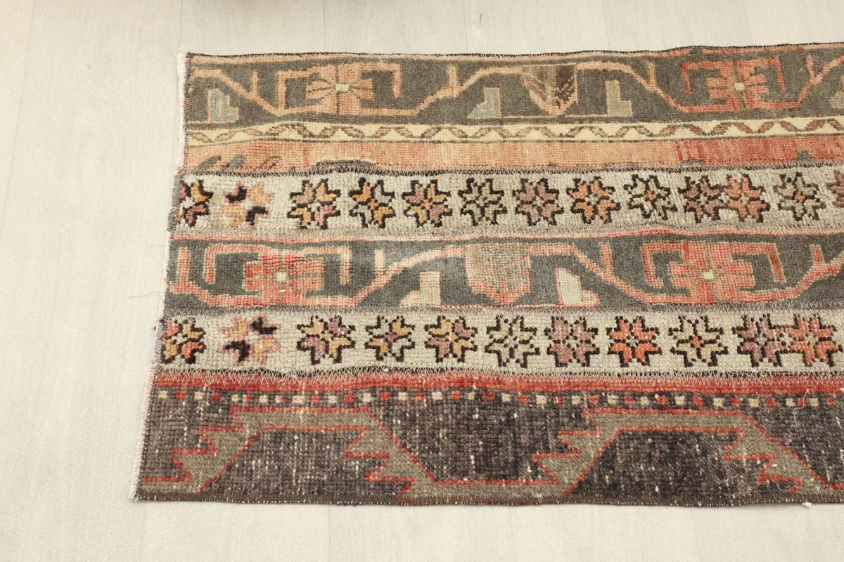 Overhead view of one end of the vintage rug, displaying the distinct striped design.