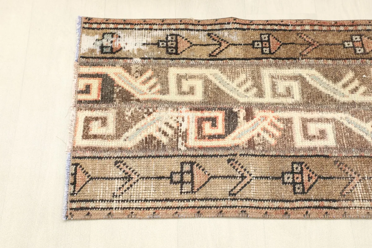 View of the rug from one end, showing the linear geometric designs and color variations