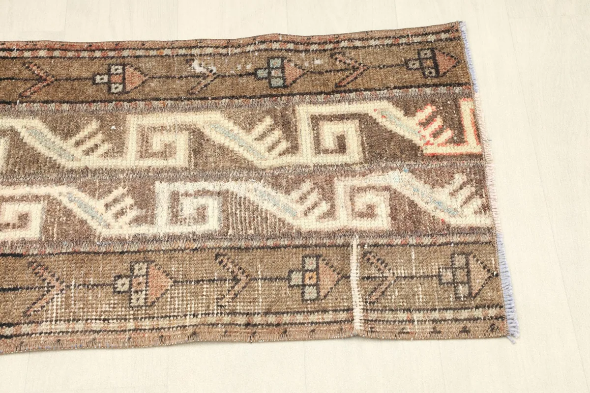 Opposite end view of the rug, displaying the low pile and the distressed look of the vintage wool