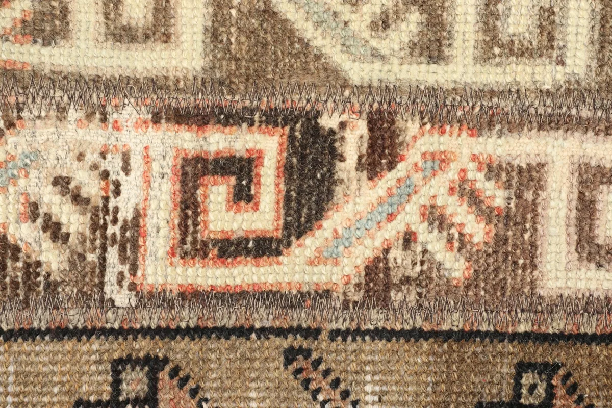 Detailed shot of the wool pile and intricate tribal patterns, including rust and blue accents
