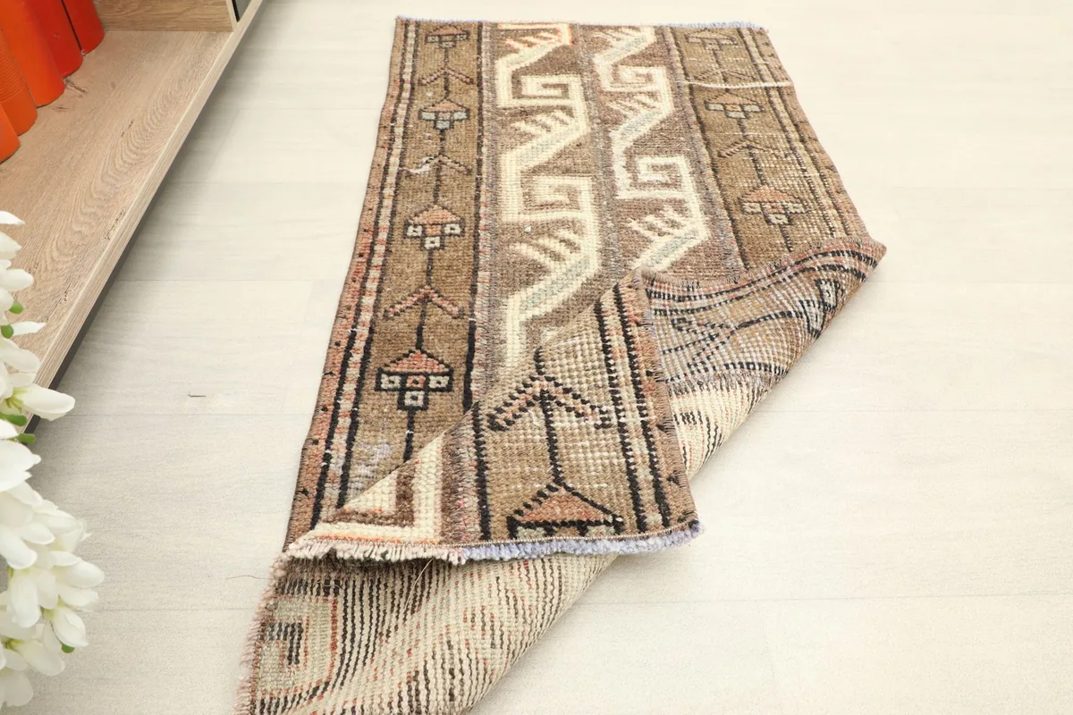 Rug partially folded, illustrating its flexibility and the overall condition of the vintage piece