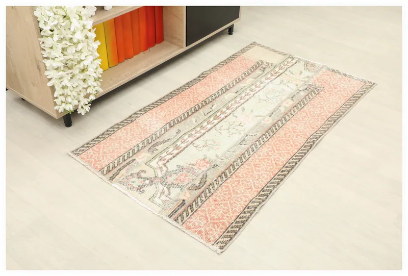 Full overhead view of the rose and cream vintage Anatolian rug on a light floor.