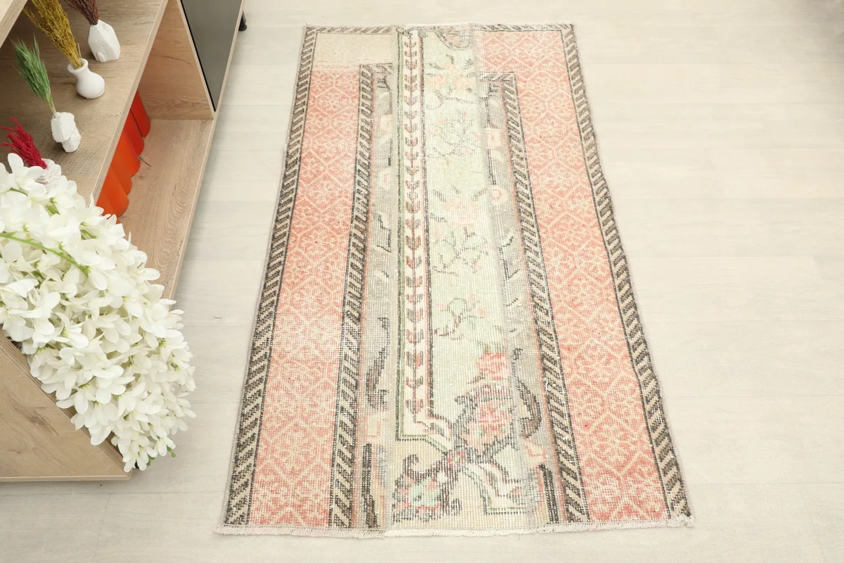 Overhead view of the rug, showing the central cream floral panel and rose geometric side panels.