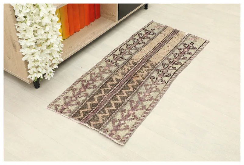 Full top view of the vintage Anatolian rug with beige, purple, and brown geometric patterns.