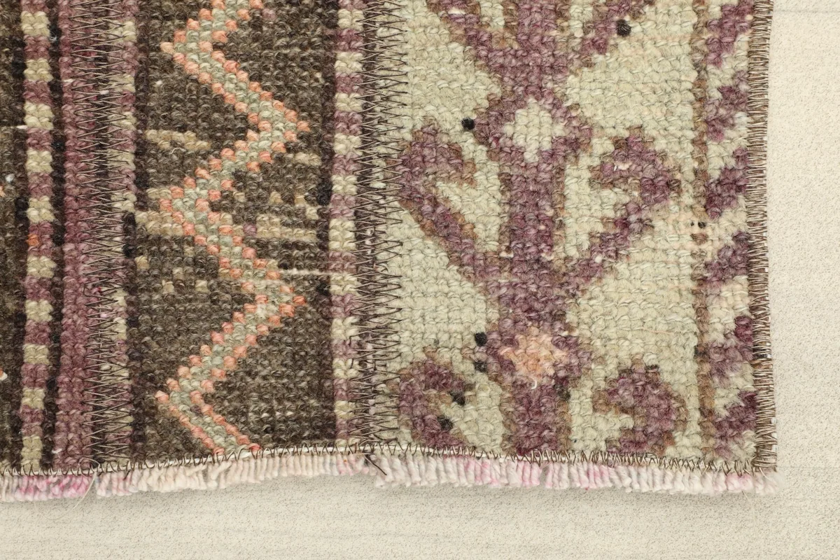 Close-up detail of the rug's edge, showing the hand-knotted wool pile and cotton foundation.