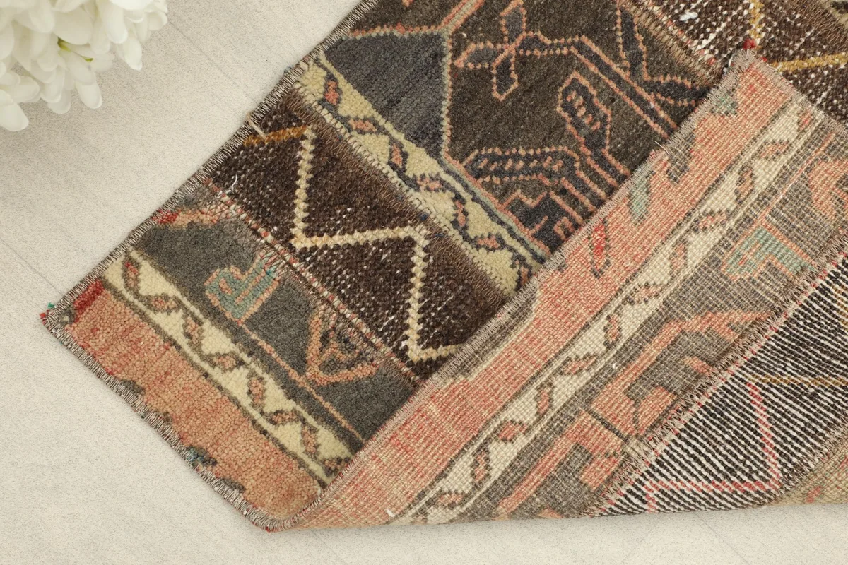 Corner of the rug folded to show the wool pile and cotton foundation