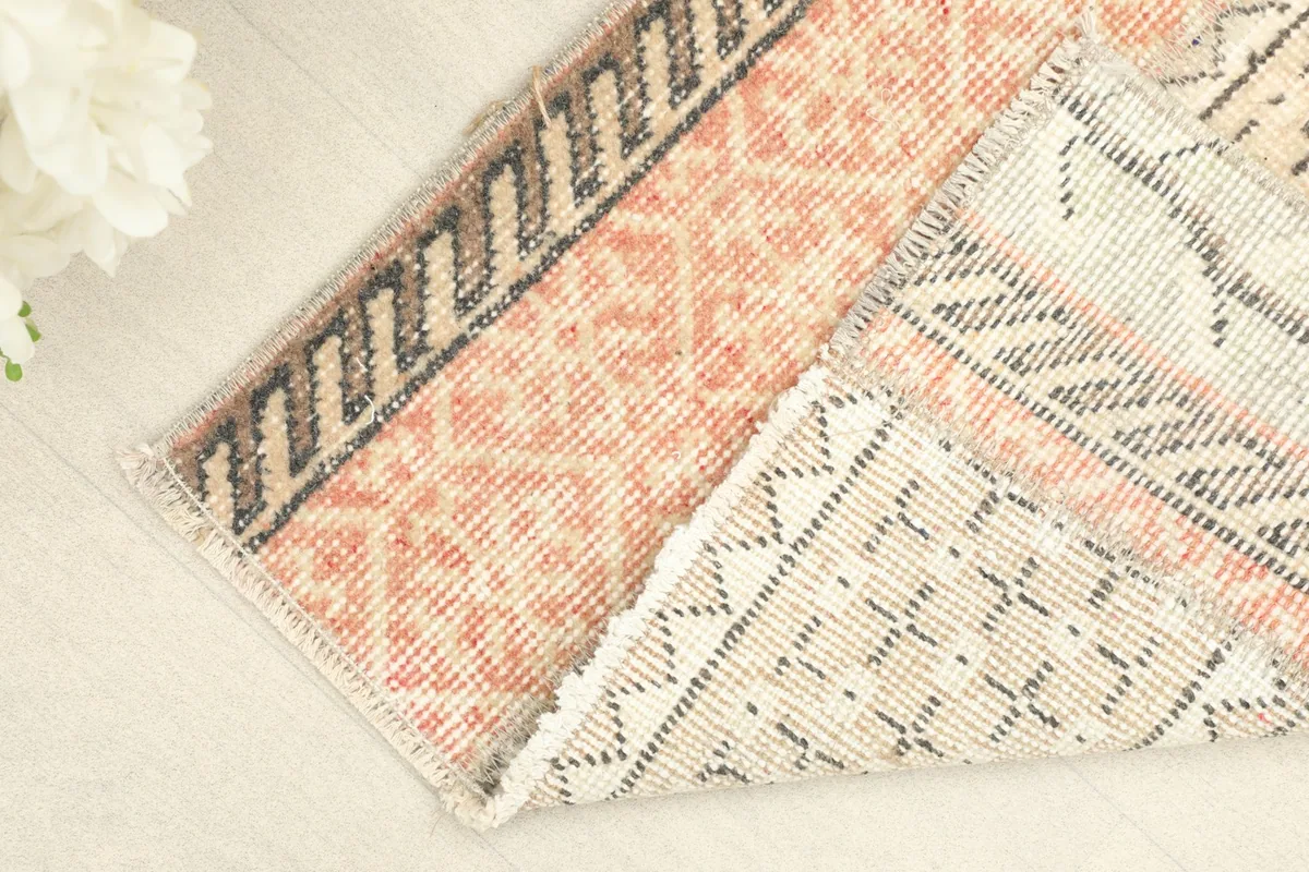Corner of the rug folded back, revealing the reverse side of the hand-knotted construction.