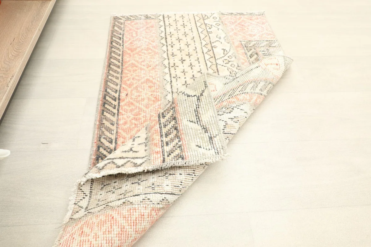 Rug folded to show its flexibility and the detailed knotting on the reverse.